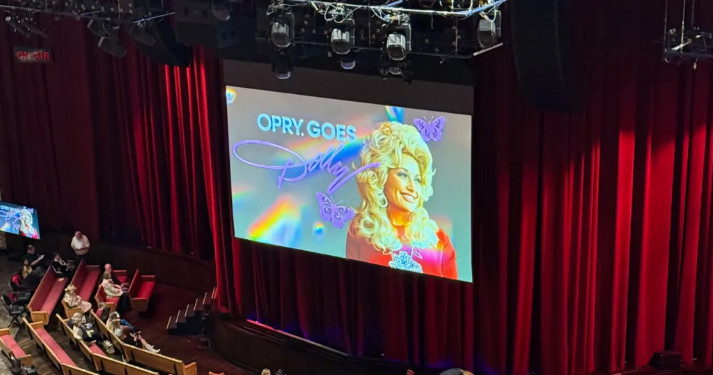 A video display reading "Dolly Goes Country."